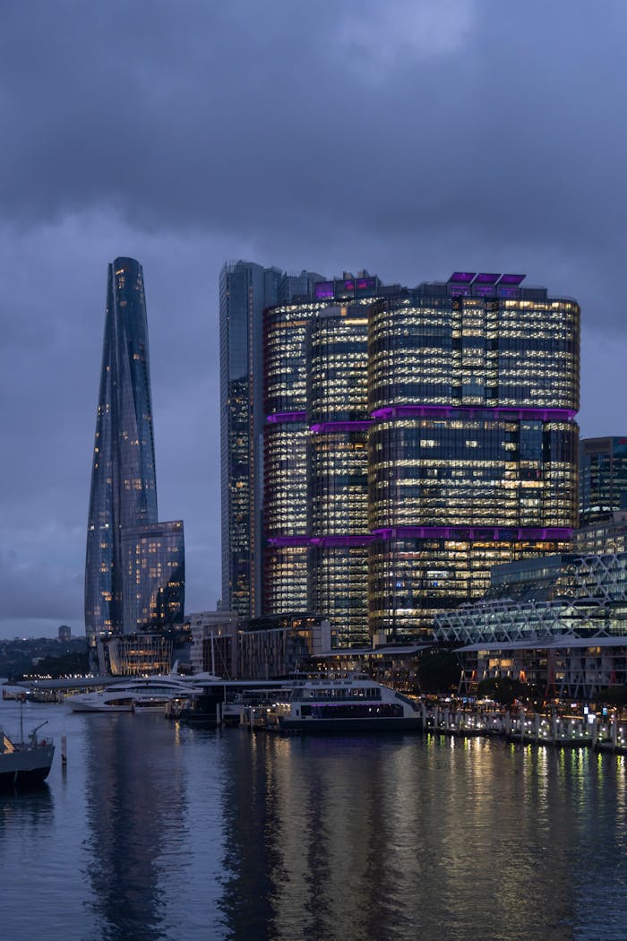 Captivating view of Sydneys iconic skyscrapers reflecting in the harbor at dusk.